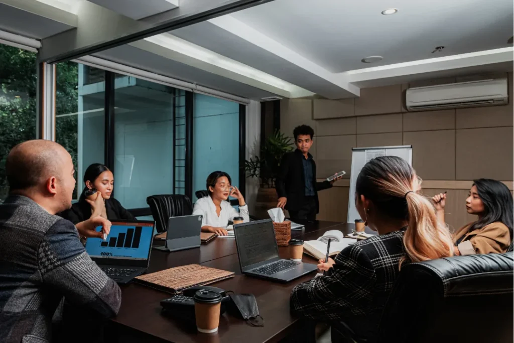 Small team in a modern boardroom with a standing presenter