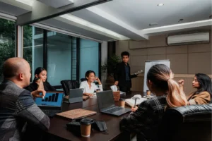 Small team in a modern boardroom with a standing presenter