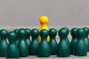 Crowd Of Dark Green Pawns With Yellow Pawn
